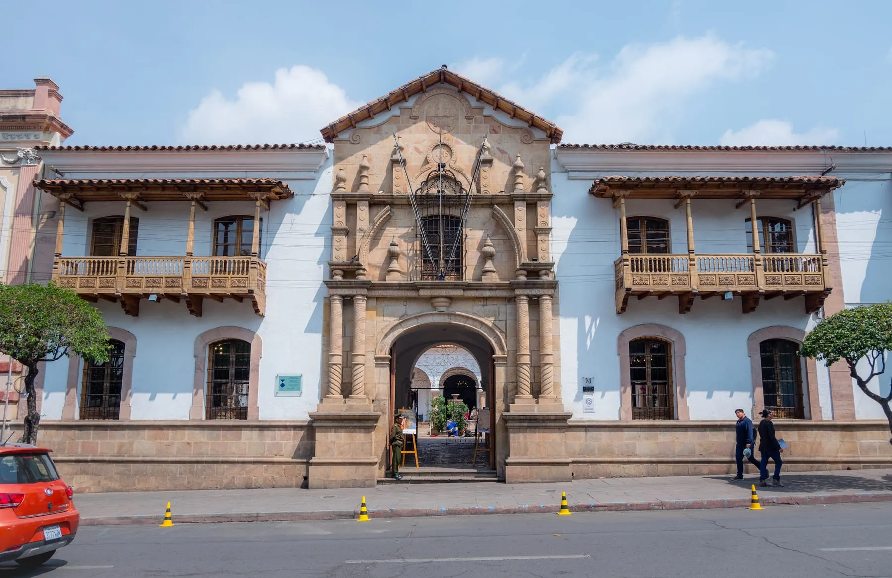 Fachada de la Casa de la Libertad en Sucre: muros celestes y blancos, portada de piedra labrada y balcones de madera tallada.